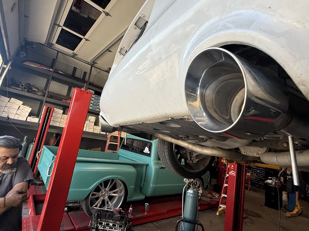 Polished exhaust tip on a classic pickup raised on a lift