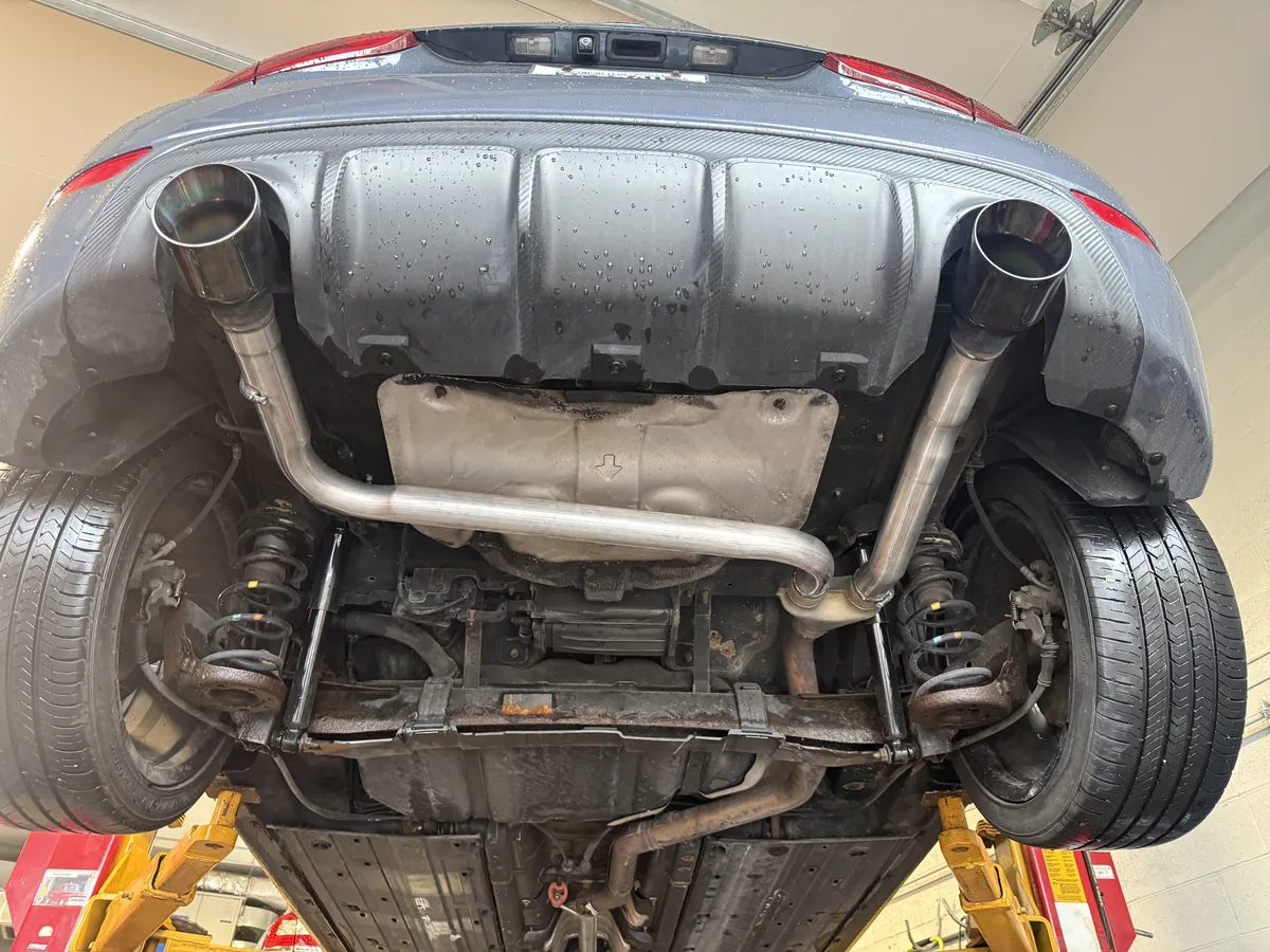 Dual exhaust system routed along the underside of a sedan