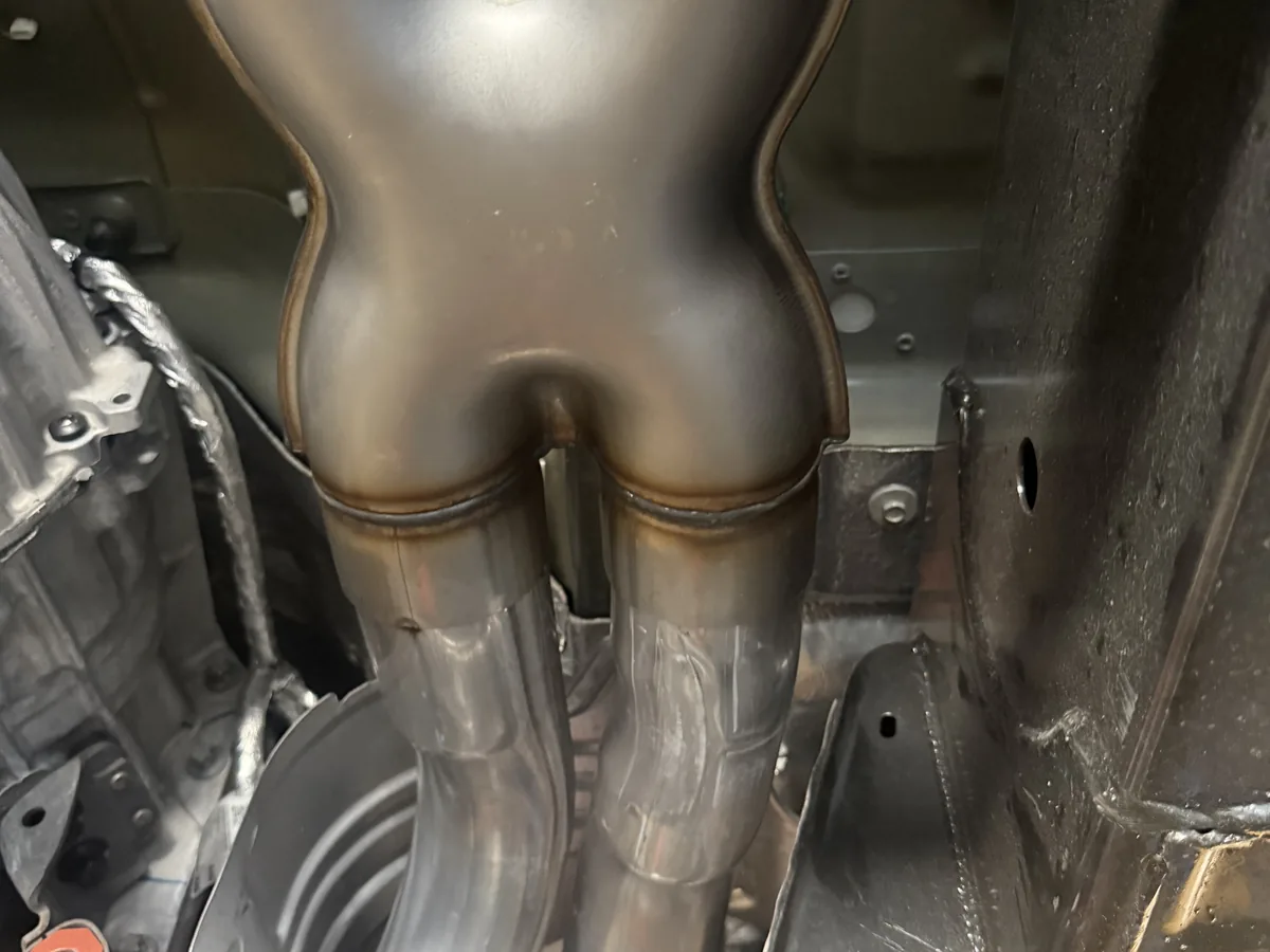 Exhaust resonator and mid pipe section beneath a vehicle