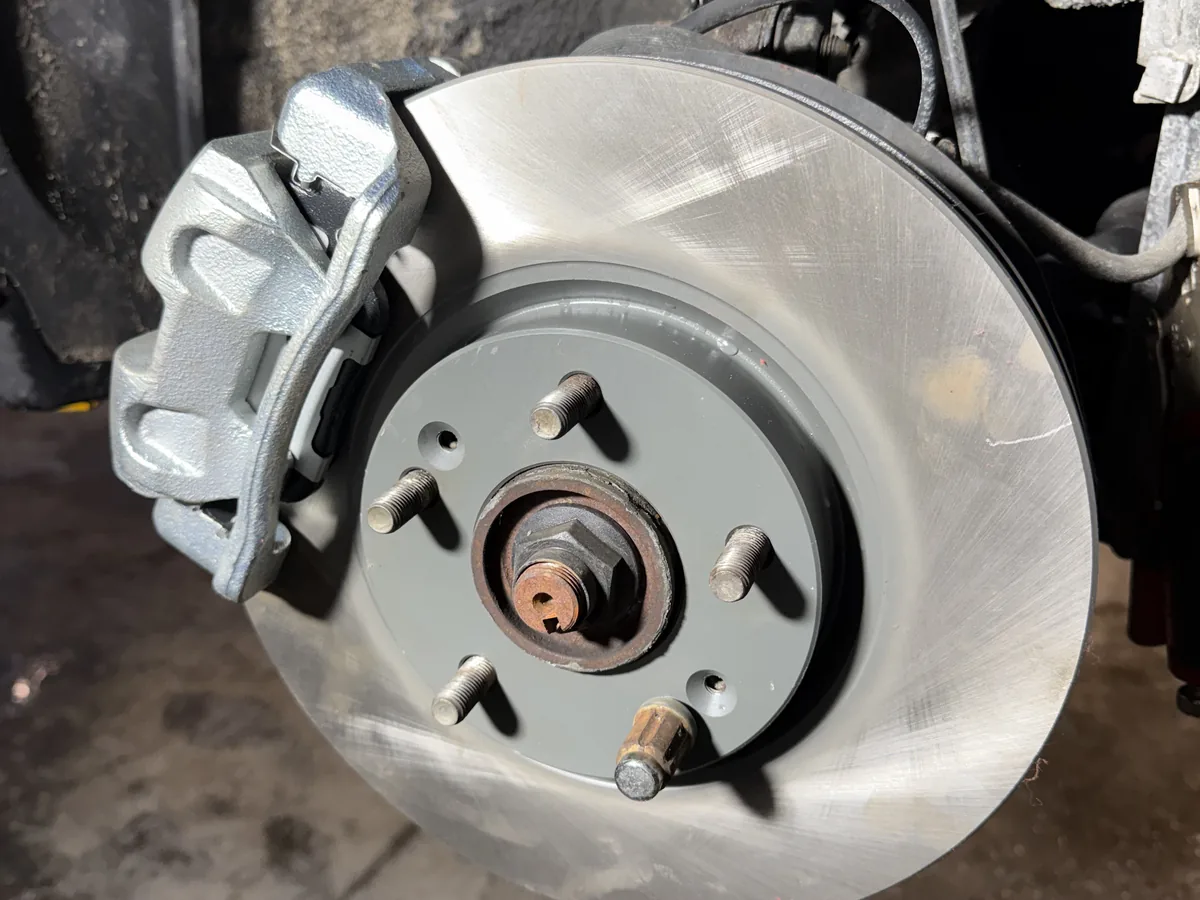 Front brake rotor and caliper exposed during a brake service