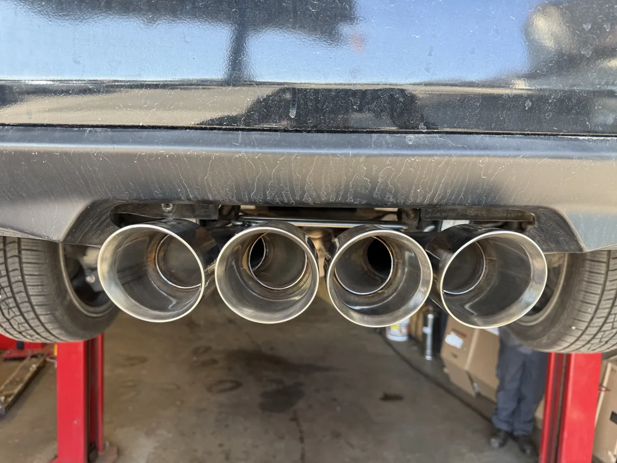 Polished quad exhaust tips fitted beneath a rear bumper
