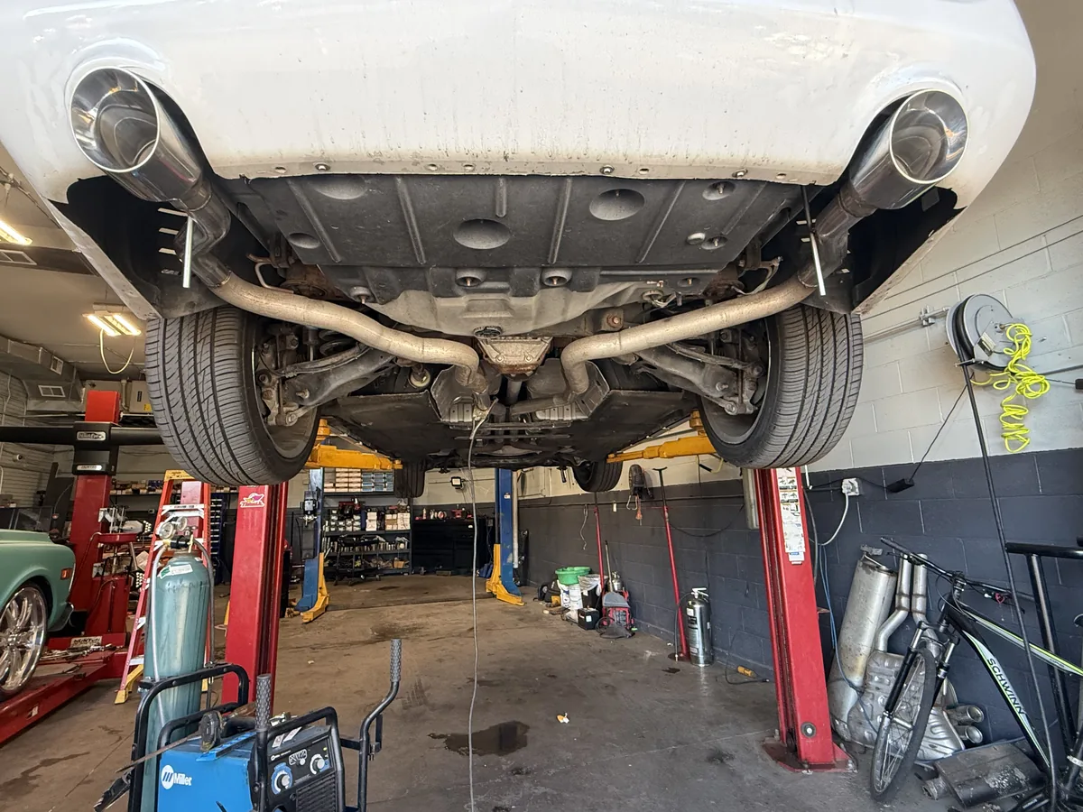 Rear exhaust piping and muffler on a vehicle raised on a lift