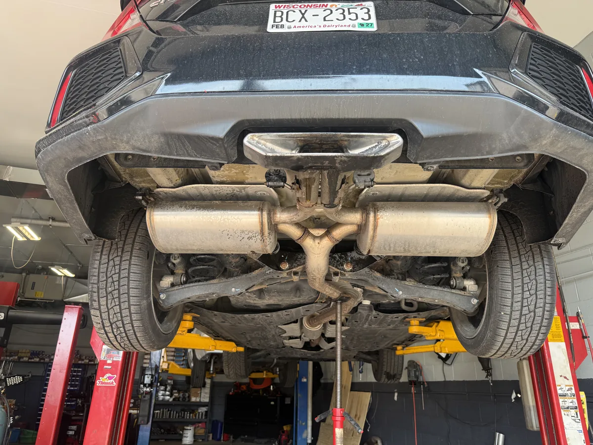 Rear underbody and exhaust of a sedan raised on a lift