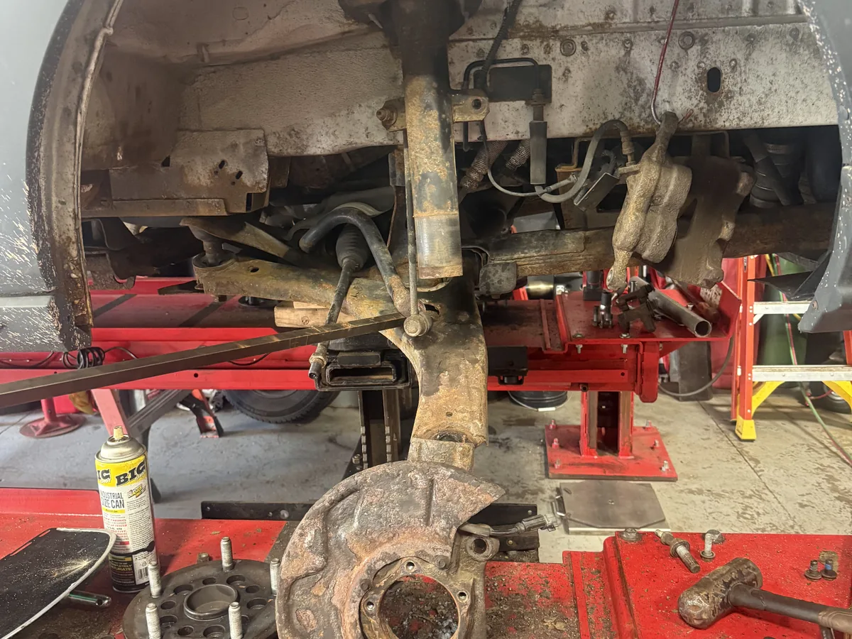 Rusted rear undercarriage and suspension components on a raised vehicle