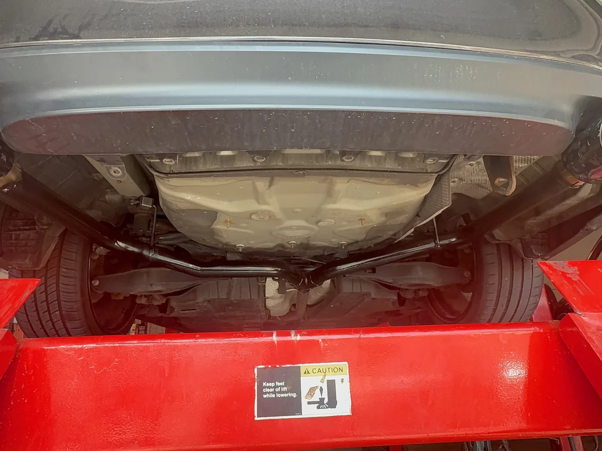 Underbody exhaust piping inspected on a raised vehicle